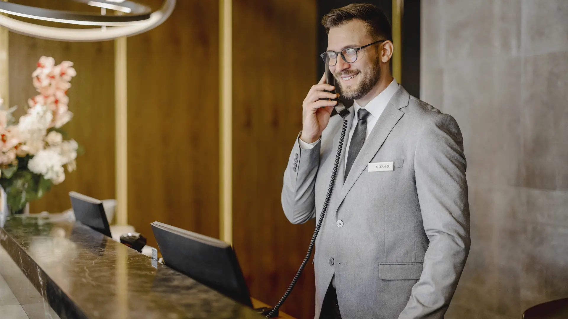 Front of house professional supporting customers at a reception desk